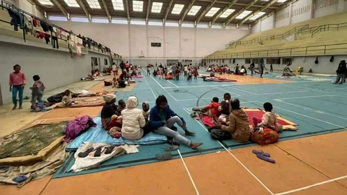 Families verzamelen zich in een sporthal om zich te beschermen tegen de cycloon. 