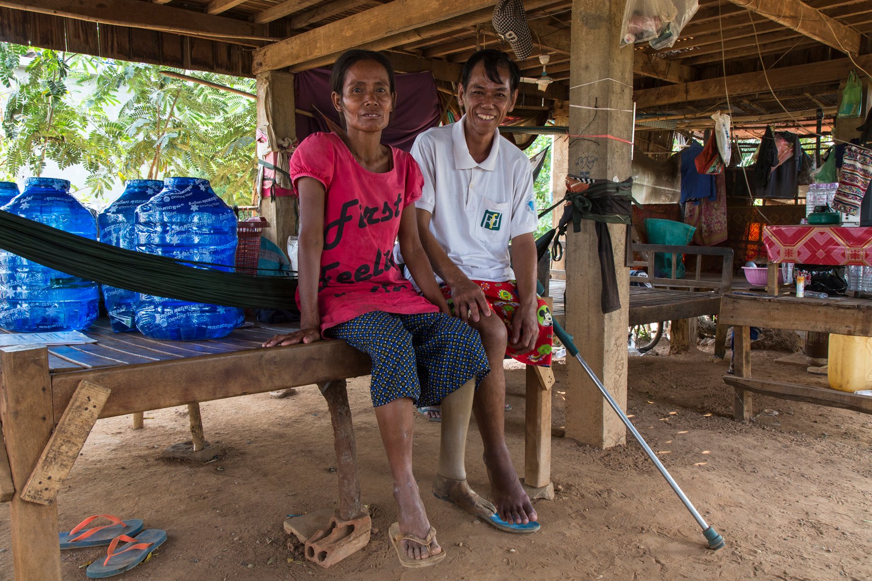 Tirean et Navea, un couple d'une cinquantaine d'année, assis l'un contre l'autre sur une plateforme traditionnelle des maisons du Cambodge