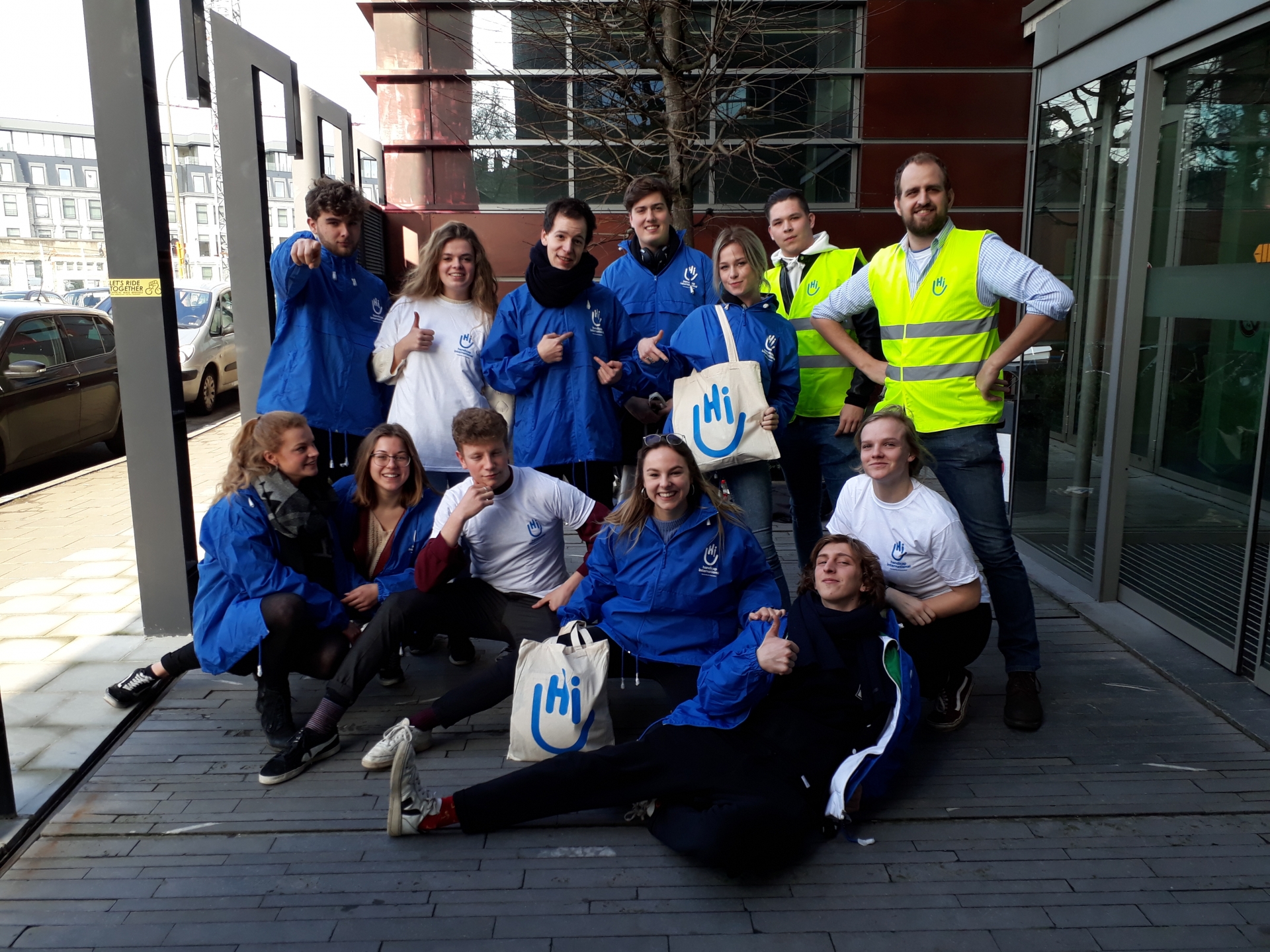 Un groupe de jeunes hommes et femmes avec les T-shirts, vestes au logo de Handicap International