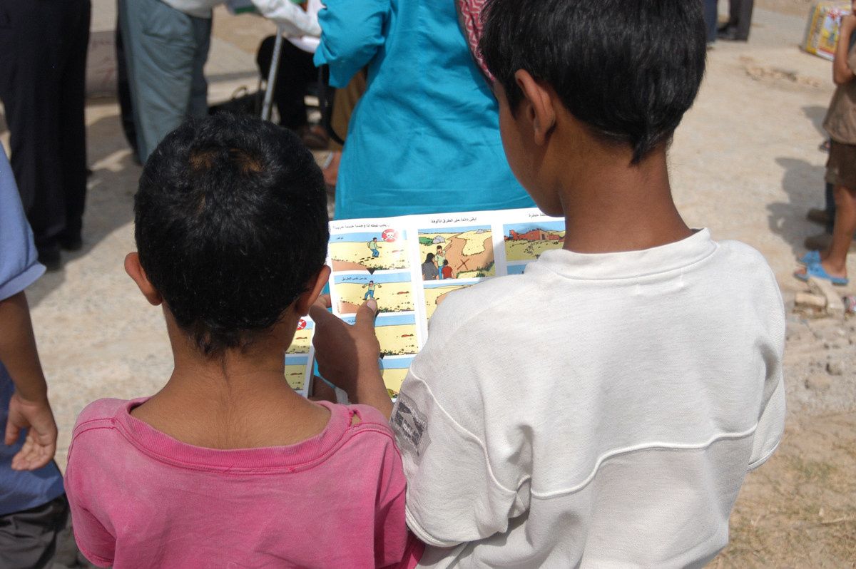 Des enfants regardent des dessins pour les sensibiliser aux dangers des mines