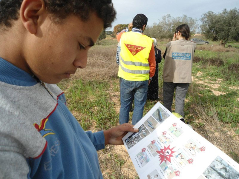 foto van een Libische jongen die leest over de gevaren van landmijnen