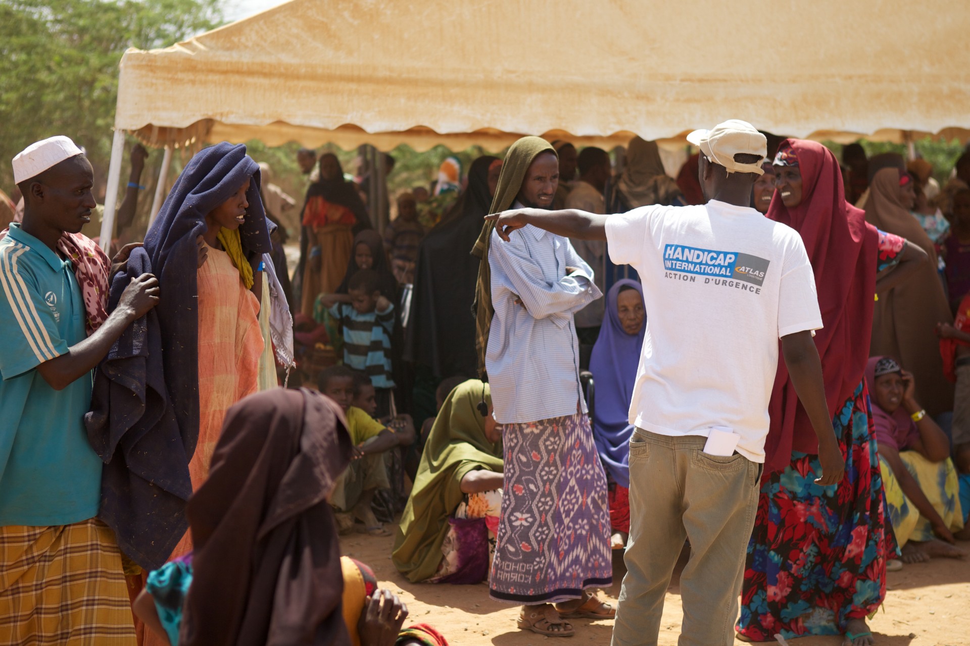 Een hulpverlener wijst mensen in Dadaab de weg.