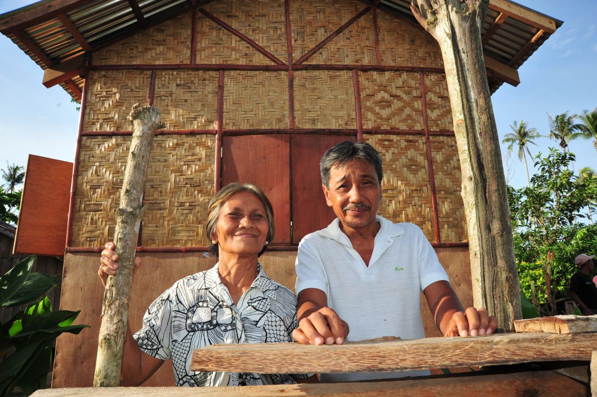 Alberto zijn vrouw Rosita voor hun huis dat gebouwd werd binnen het Shelterproject van Handicap International na Haiyan